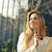 Smiling businesswoman holding smartphone and tablet outdoors in Milan.